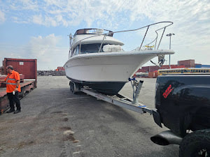 Oversized boat hauled by RGN lowboy boat trailer. 